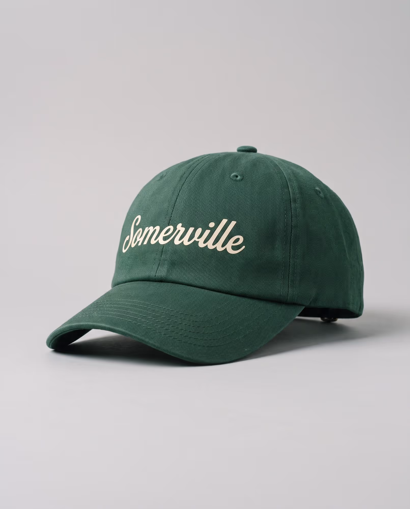 Forest green cap with "Somerville" printed across the front in cream script