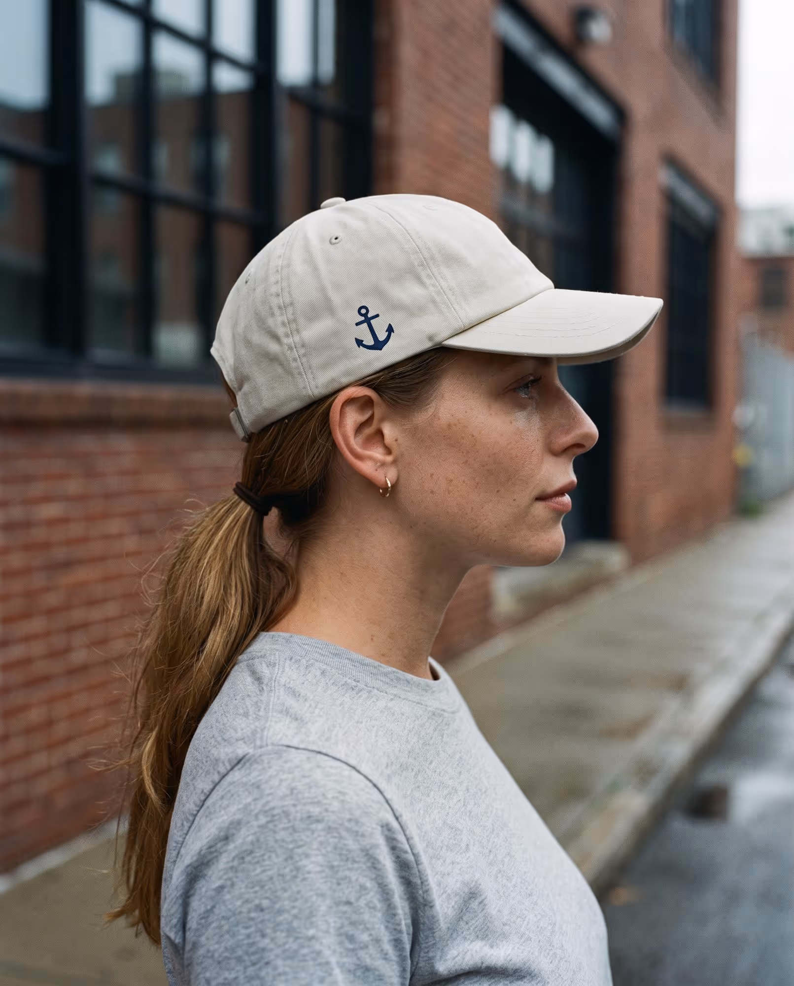 Stone dad hat with a small navy anchor printed on the side panel