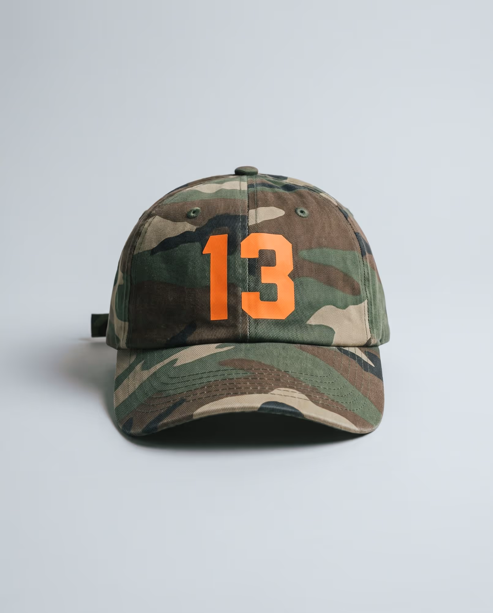 Woodland camo cap with the number 13 printed in bright orange on the front panel