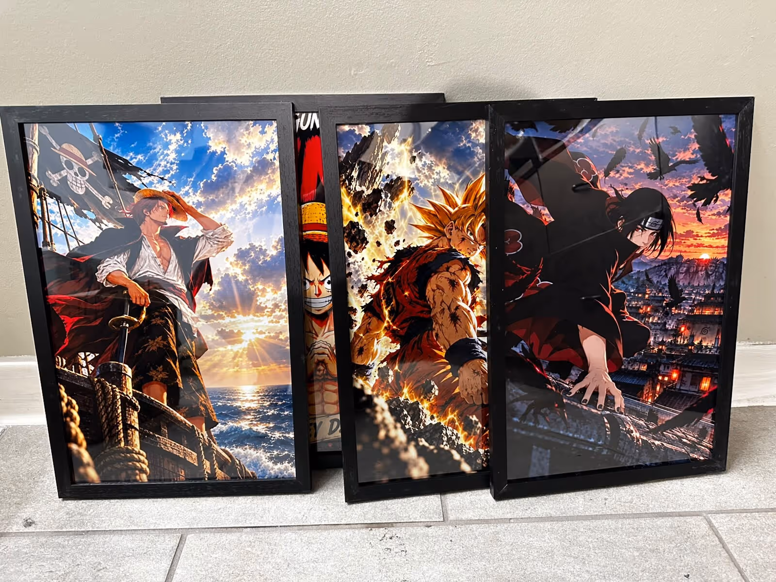 Four black wooden frames with anime-style posters leaning against a wall on a tiled floor, made in the shop