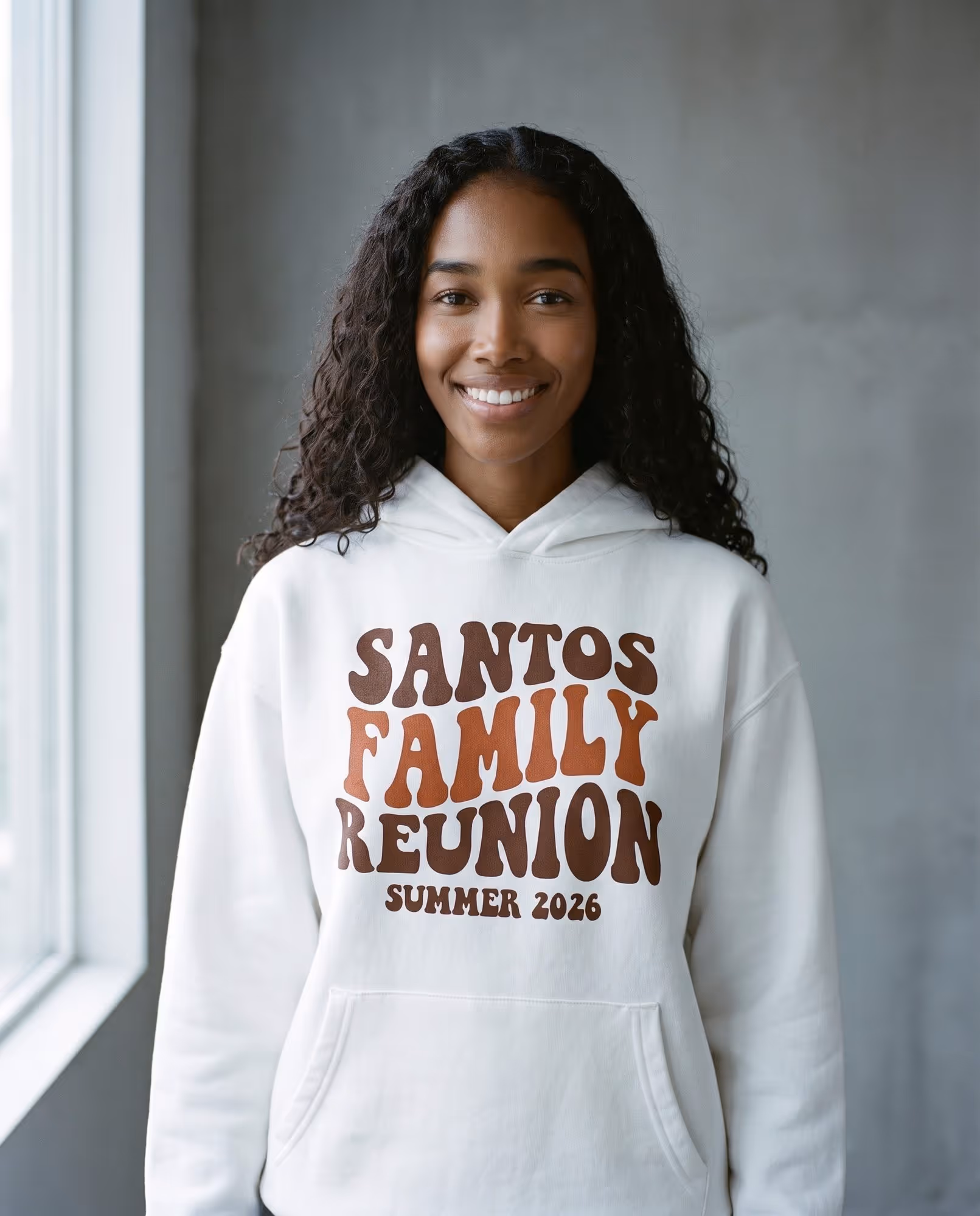 White hoodie with "Santos Family Reunion, Summer 2026" printed in retro brown lettering