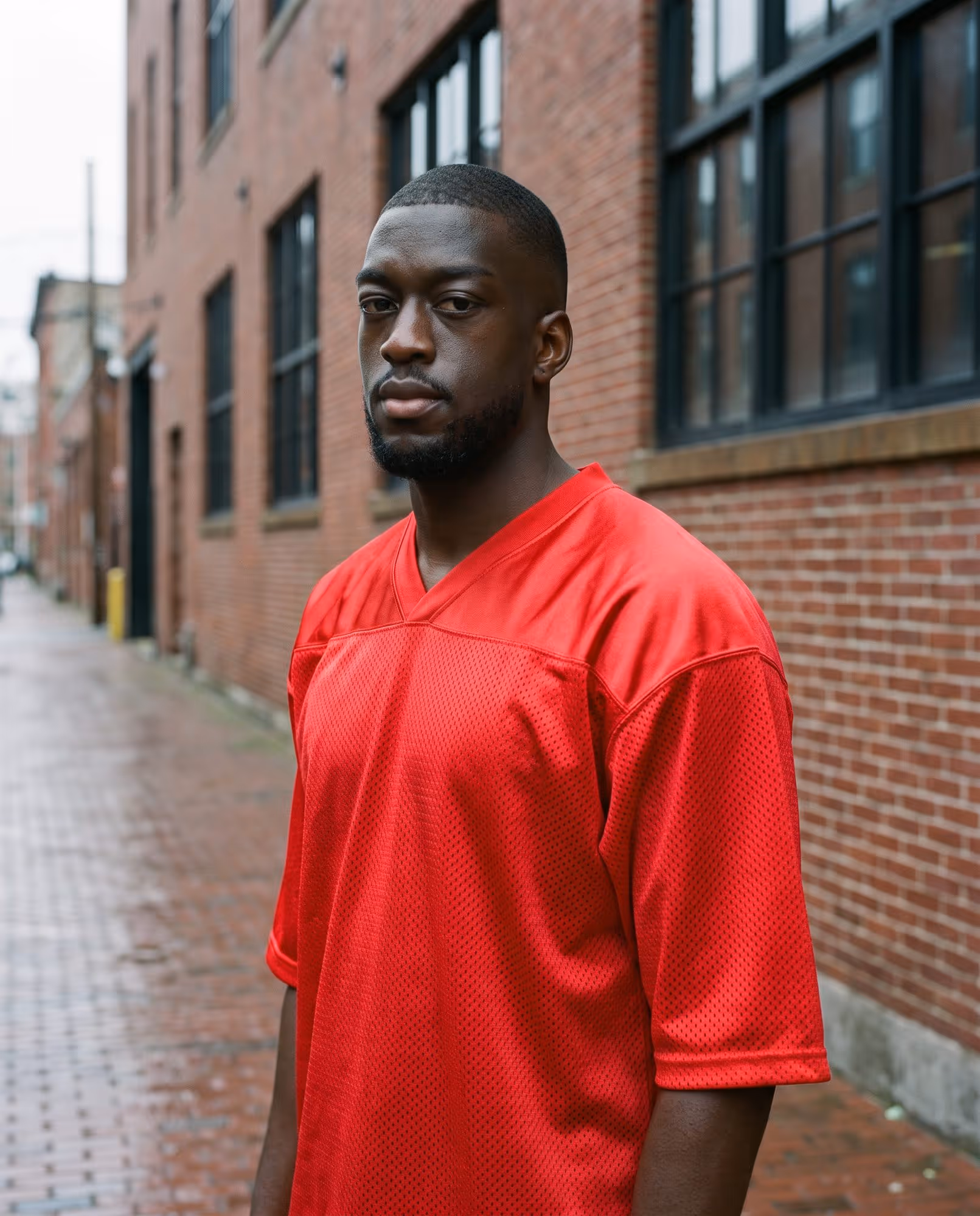 Plain red mesh football jersey blank, three-quarter view showing the drop shoulder