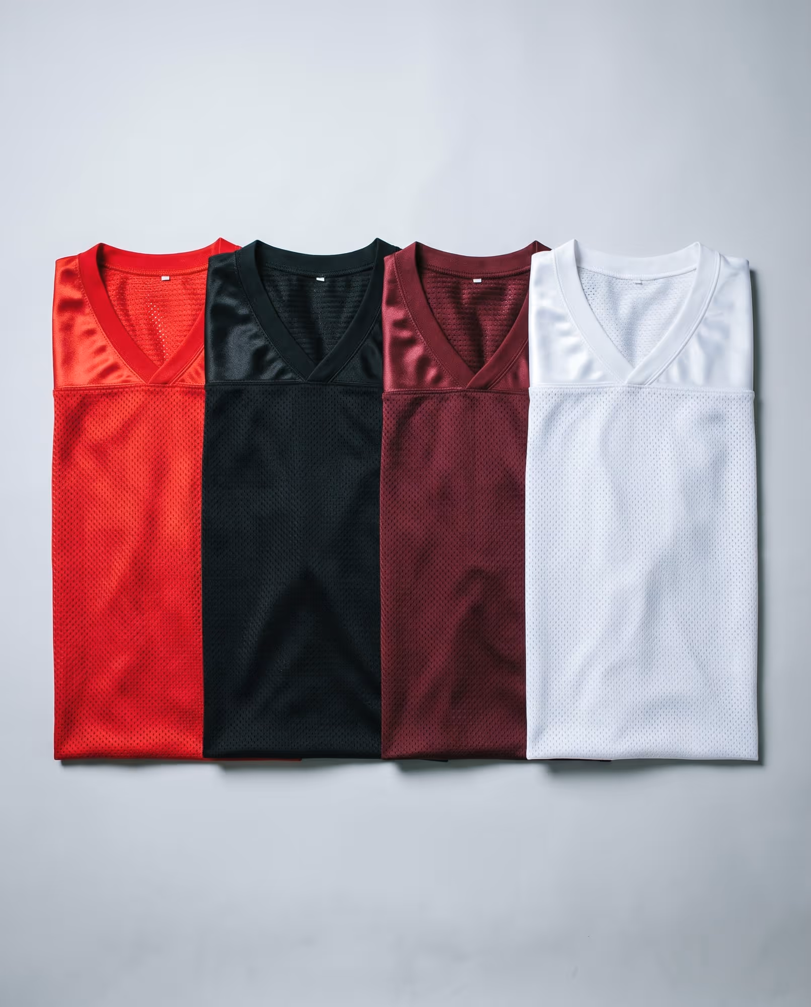 Red, black, maroon and white mesh jersey blanks laid side by side