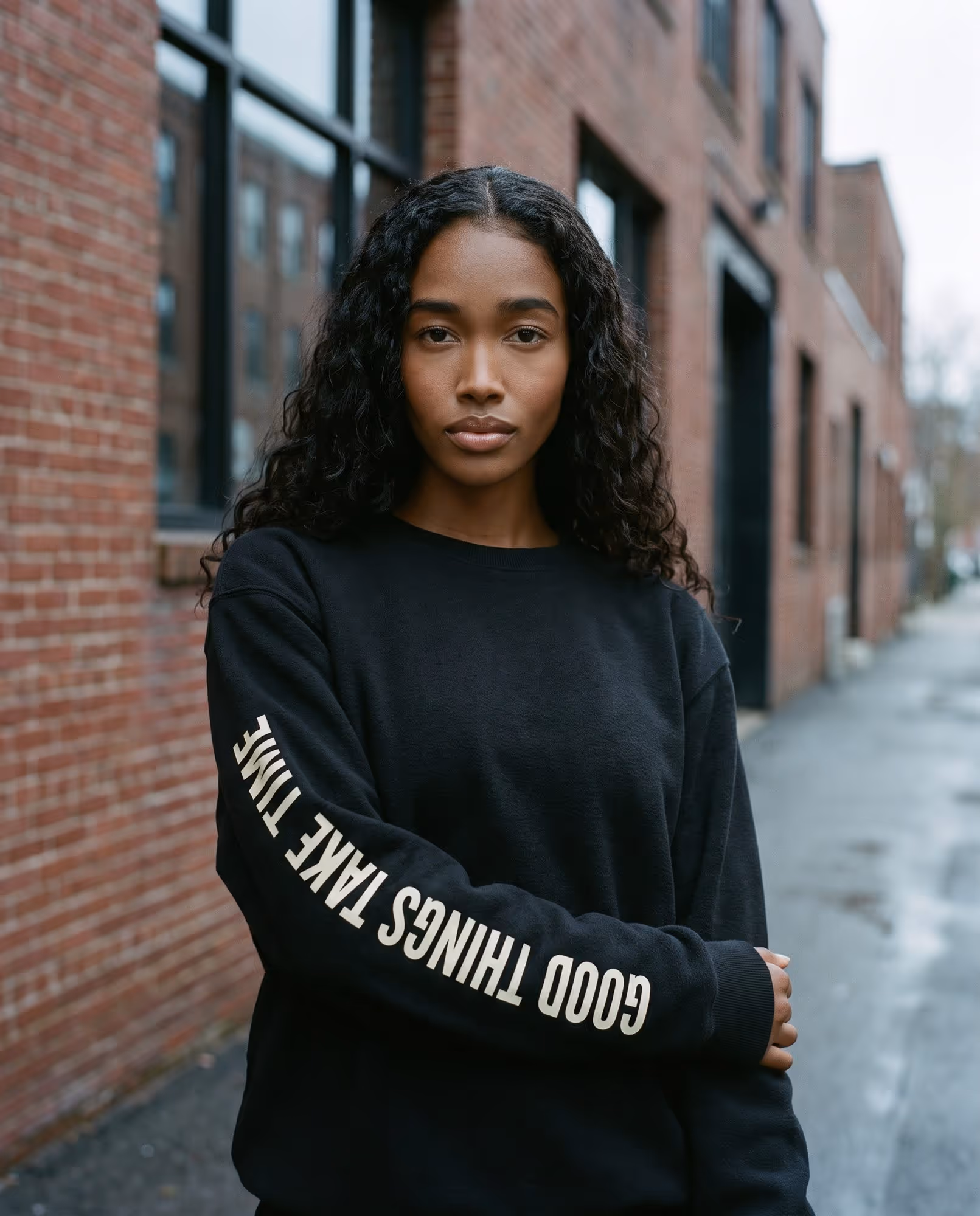 Black crewneck sweatshirt with Good Things Take Time printed down the sleeve