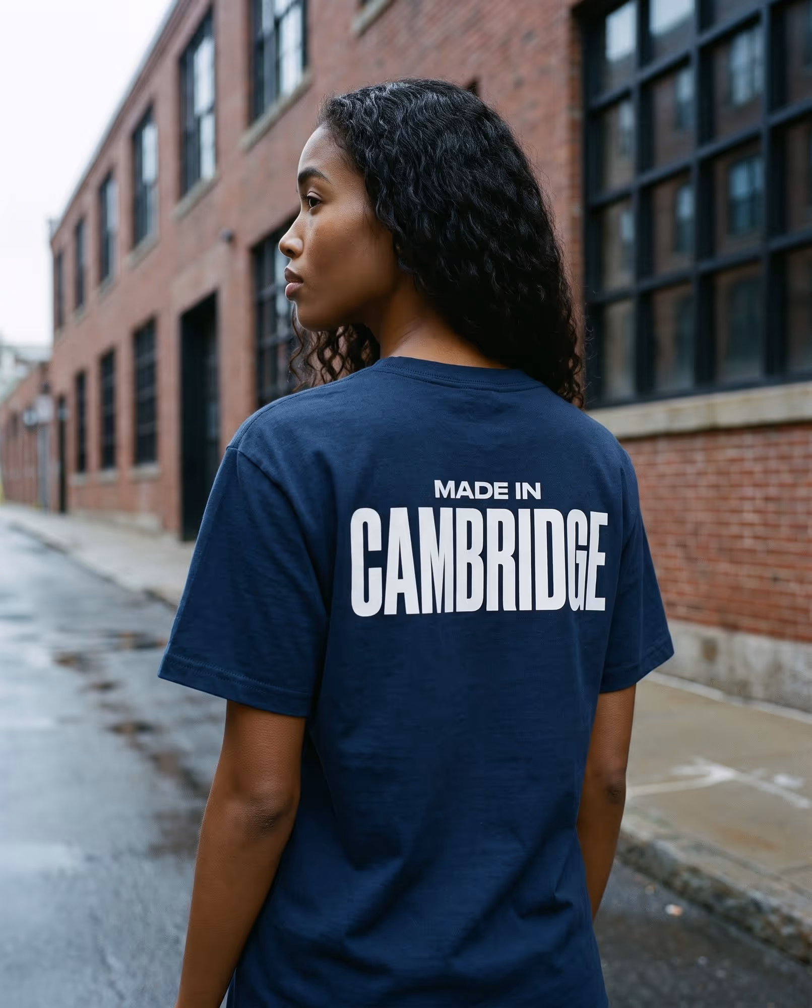 Back of a navy t-shirt printed with "Made in Cambridge" in white condensed type