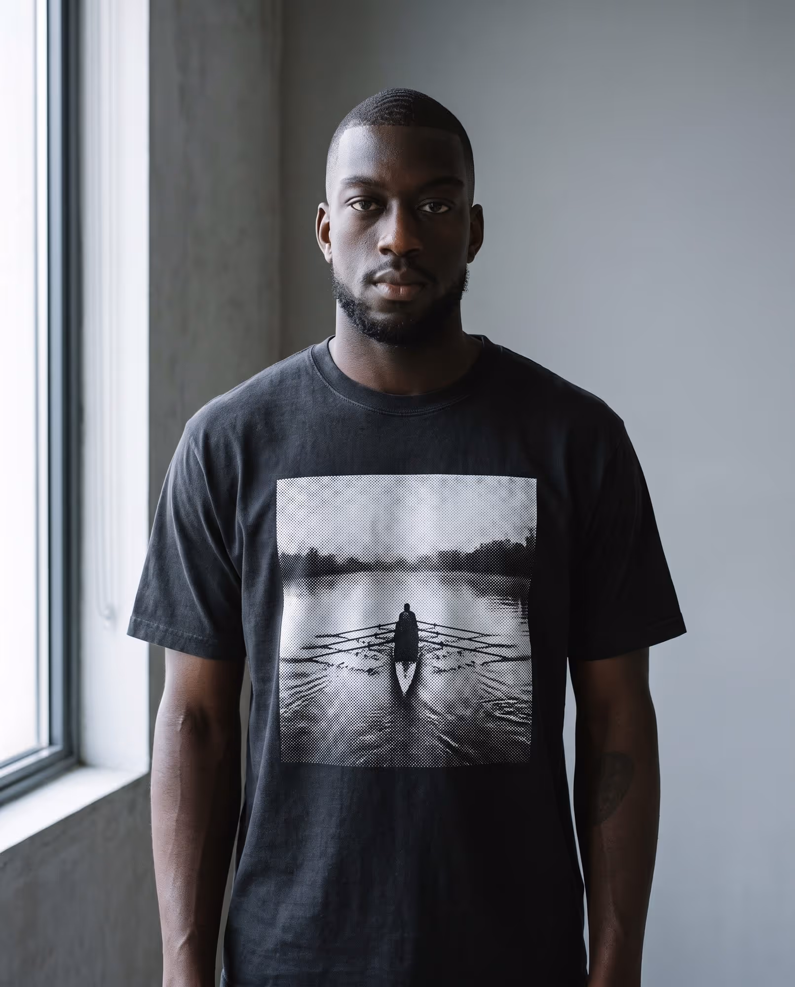 Washed black t-shirt with a black-and-white halftone photo of a rowing shell printed on the chest