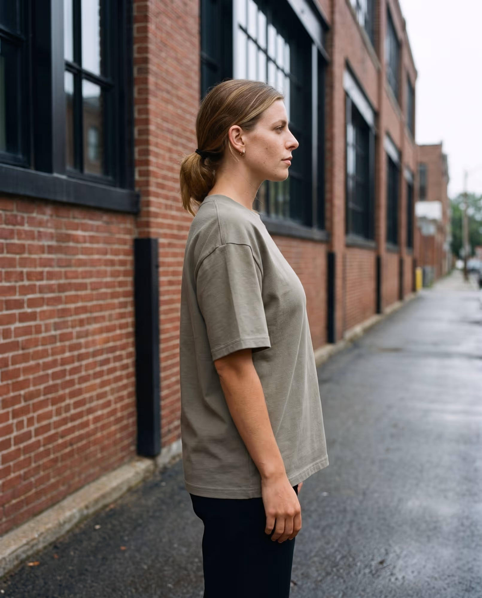 Plain sage oversized t-shirt seen in profile, the dropped shoulder seam running down the arm